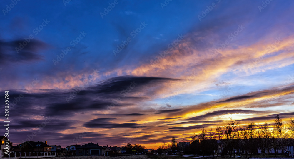 Dramatic sunset skies in early spring with tree tops Dramatic sunset skies in early spring with tree tops