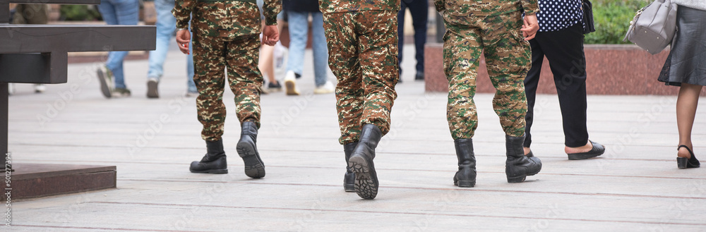 Soldiers on uniform walking in the city.