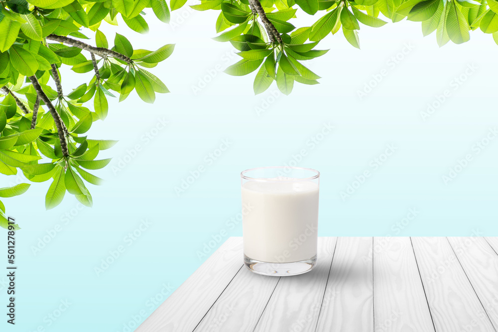 Glass of milk on white wooden table with blue background. Glass of milk on white wooden table with blue background.