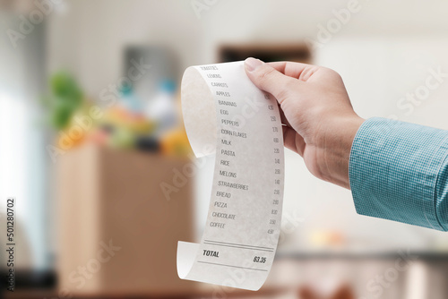 Woman checking a grocery receipt photo