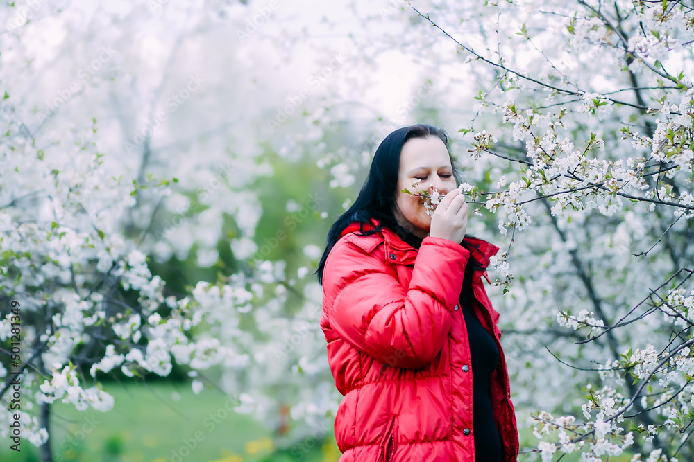 Happy young woman enjoys spring blossoms. Blooming cherry trees. Happy young woman enjoys spring blossoms. Blooming cherry trees.