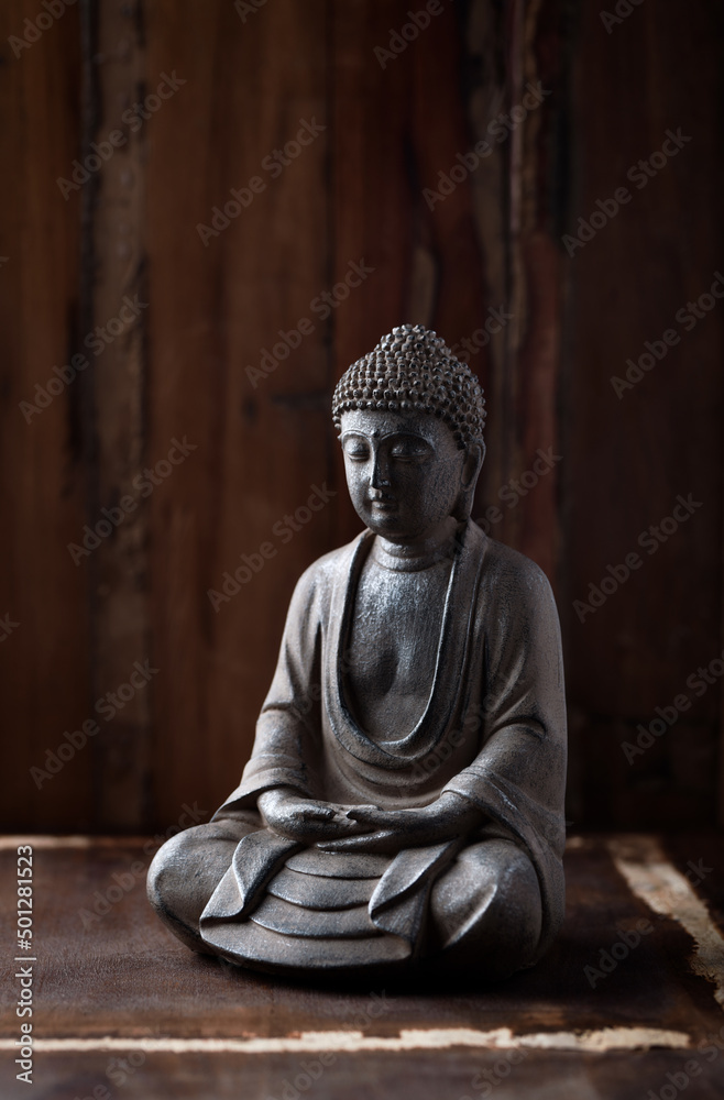 Meditating Buddha Statue on dark wooden background. Close up.
