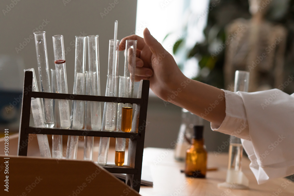 Obraz premium hands of woman working in hemical or biologic laboratory with samples in tubes