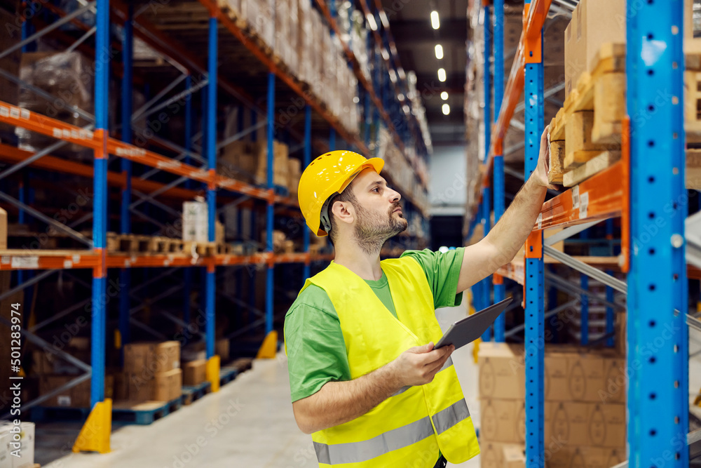 A storage worker with tablet checking on orders. A storage worker with tablet checking on orders.