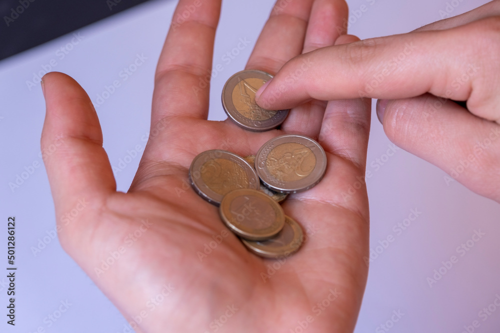 Coins on male hand isolated on white background, counting coins with forefinger, saving money concept Coins on male hand isolated on white background, counting coins with forefinger, saving money concept