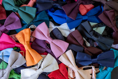 Colorful bow ties texture, pile of bow ties spilled on the floor, top view neck tie backdrop, lay down man fashion concept