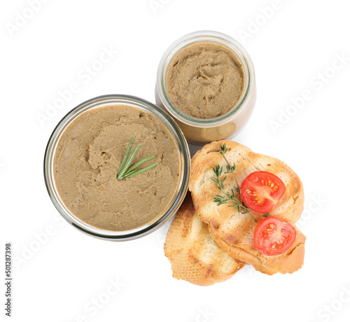 Glass jars with tasty liver pate, bread and tomato on white background, top view