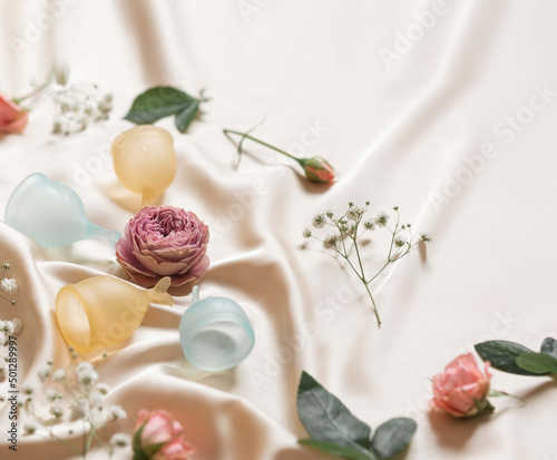 multicolored menstrual cups on a silk background