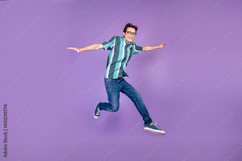 Full length photo of young man good mood jump up fly energetic isolated over violet color background