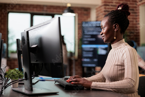 Confident african american network developer engineering application for company database. Cyber security team member developing advanced firewall system in order to protect encrypted files.