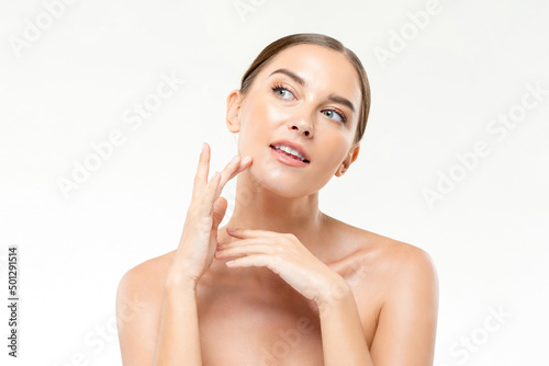 Caucasian woman applying cosmetic product on face