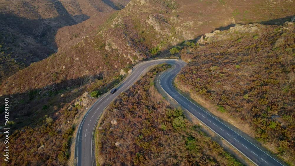 Drone Of Single Car Driving Along Empty Winding Road Drone Of Single Car Driving Along Empty Winding Road