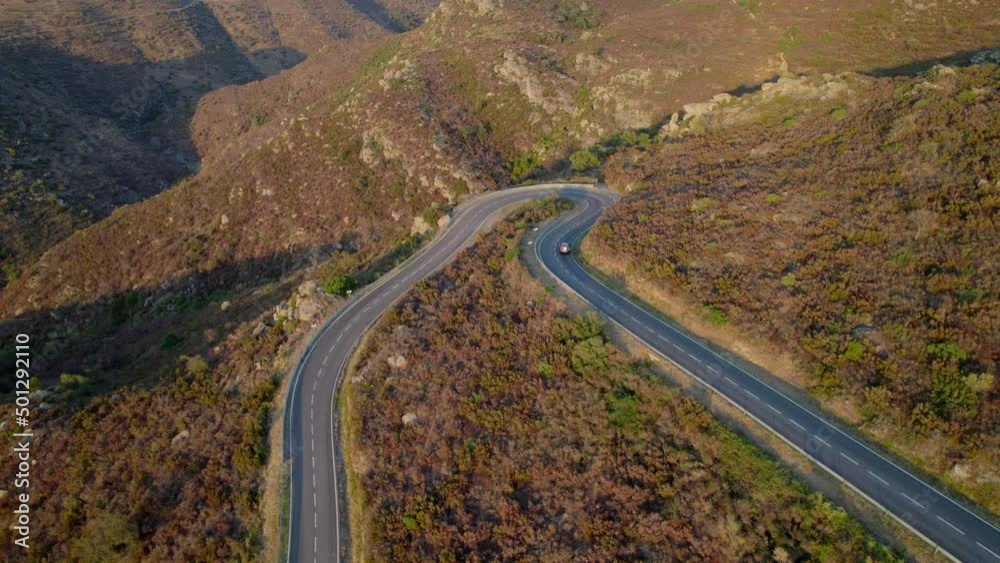 Drone Of Single Car Driving Along Empty Winding Road Drone Of Single Car Driving Along Empty Winding Road