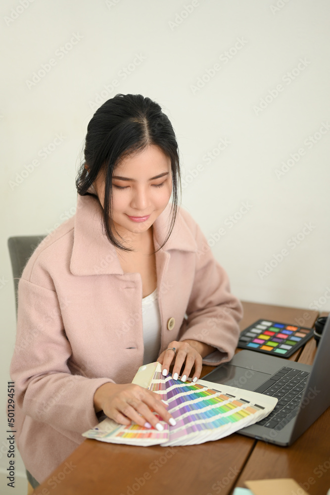 Professional millennial female graphic designer working at her office desk Professional millennial female graphic designer working at her office desk