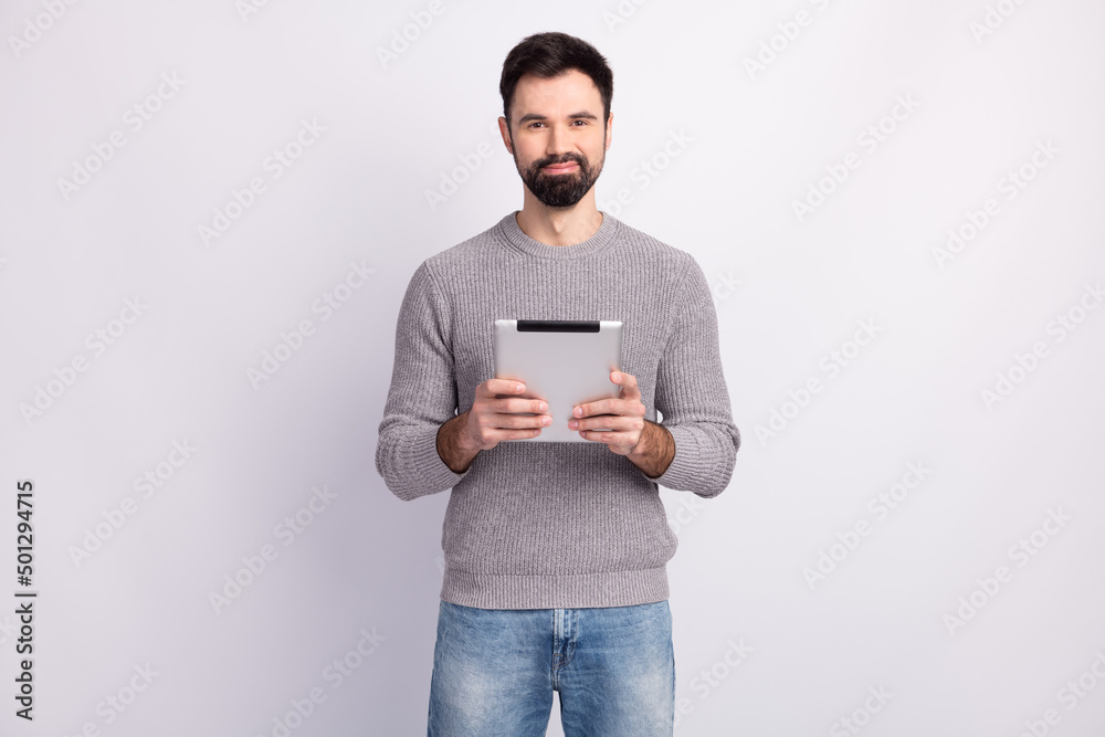 Photo of young business man hold tablet agent manager browse news isolated over grey color background Photo of young business man hold tablet agent manager browse news isolated over grey color background