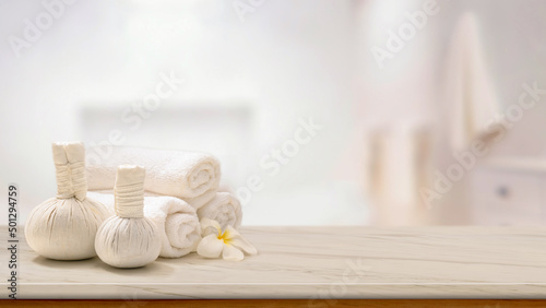 Massage herbal balls with towels and copy space on white marble tabletop