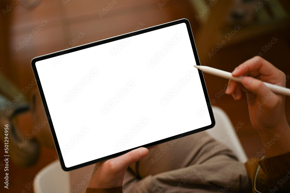 Female hands holding stylus pen and using tablet white screen mockup.
