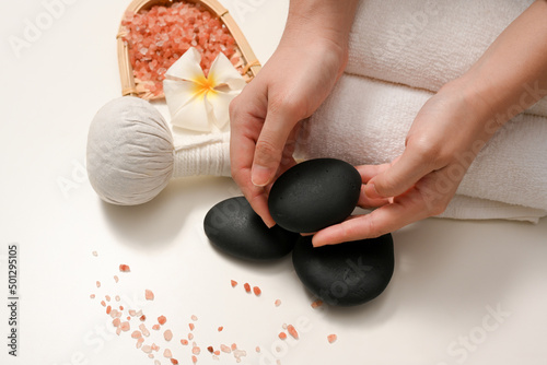 Female hands holding a spa stone massage or zen stone massage.