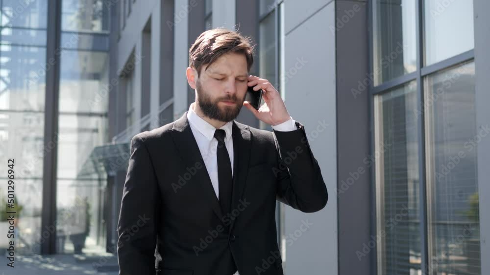Hipster young smart businessman talking in telephone in city. The man wearing stylish suit walking to working having phone call outdoor. Telecommunication and mobile network for business concept. Hipster young smart businessman talking in telephone in city. The man wearing stylish suit walking to working having phone call outdoor. Telecommunication and mobile network for business concept.