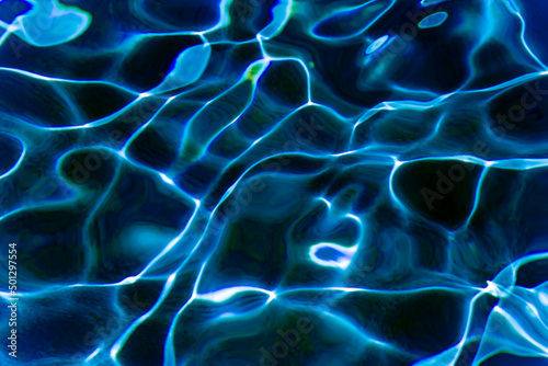 Dark blue water with sunlight reflections texture background. Ripples and glare on the swimming pool surface.