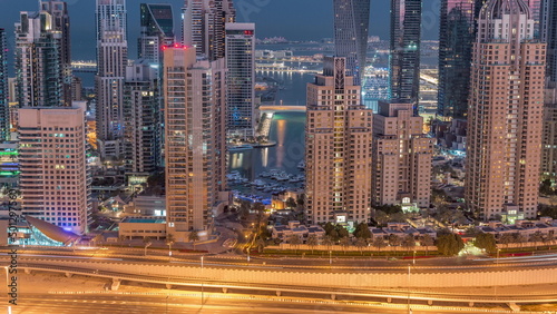 Skyscrapers of Dubai Marina near intersection on Sheikh Zayed Road with highest residential buildings night to day timelapse