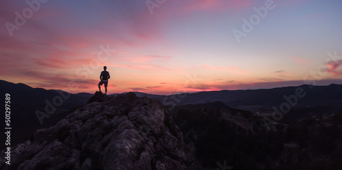 Viajero en la cima de una montaña, en la hora del atardecer. Foto en horizontal, con espacio para texto.