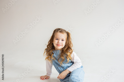 beautiful cute baby girl lies on her stomach and looks into the camera with slightly wavy hair. pretty Baby. happy childhood.