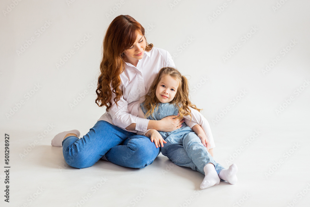 Full length happy woman in plain white t-shirt sitting cheerfully on the floor Full length happy woman in plain white t-shirt sitting cheerfully on the floor