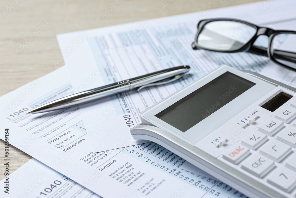 Calculator, documents, glasses and pen on wooden table, closeup. Tax accounting Calculator, documents, glasses and pen on wooden table, closeup. Tax accounting