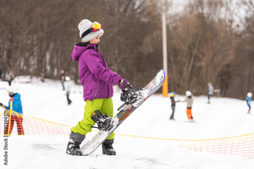 Snowboard winter sport. Cute girl with snowboard going to slide in winter nature Snowboard winter sport. Cute girl with snowboard going to slide in winter nature
