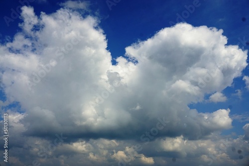 Großes weißes Wolkengebilde an blauem Himmel bei Sonne im Frühling 