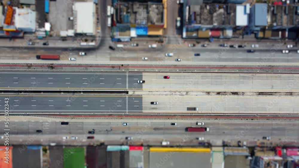 Traffic on a straight road that runs through a small town with very little traffic. Video taken from a high angle
