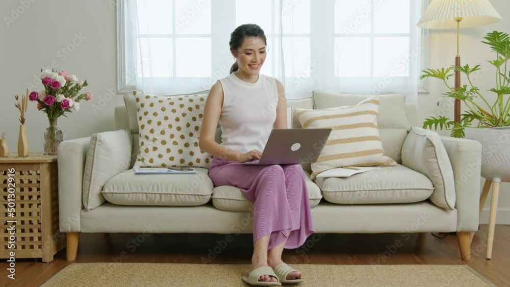 young Asian businesswoman using computer laptop working on couch. work from home concept. young Asian businesswoman using computer laptop working on couch. work from home concept.
