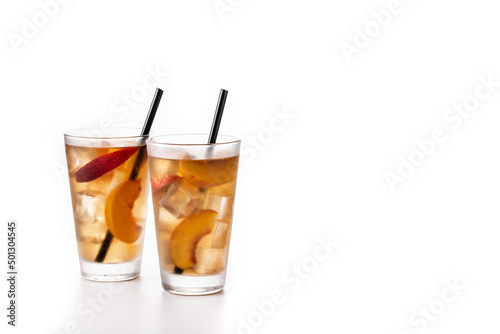 Glass of peach tea with ice cubes isolated on white background. Copy space