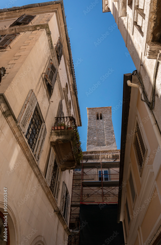 View looking up at building facades and bell tower in a narrow alley in the Diocletian's Palace in the ancient city of Split, Croatia