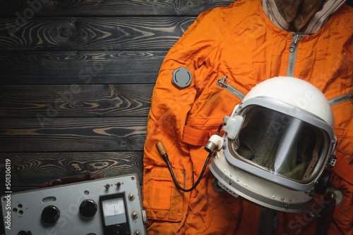 Concept of astranaut helmet and space suit on the old table flat lay background with copy space. photo