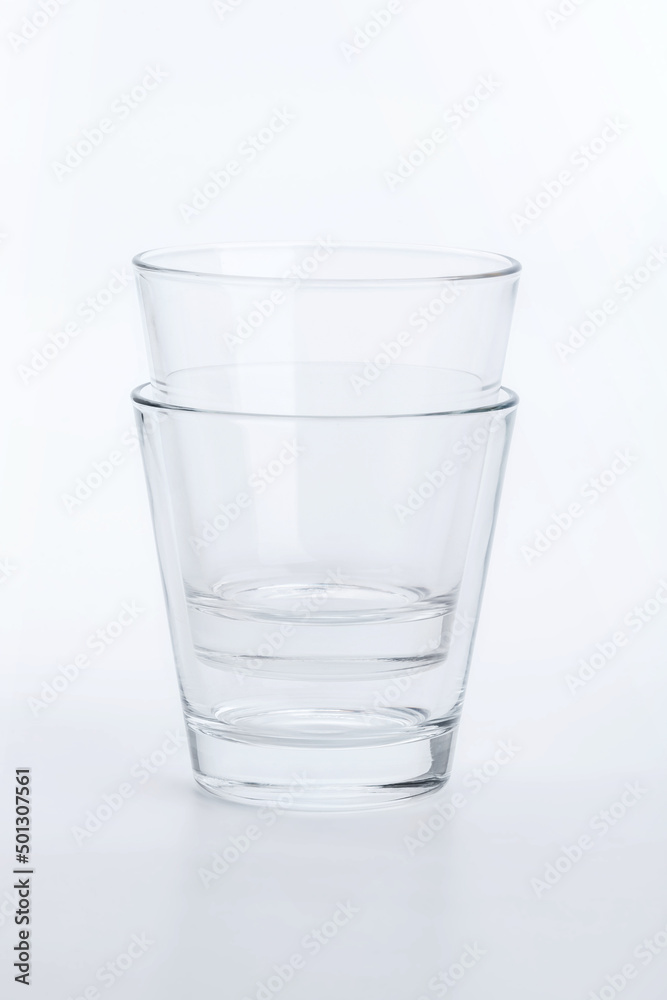 Two classic shape empty glasses on a white surface Two classic shape empty glasses on a white surface