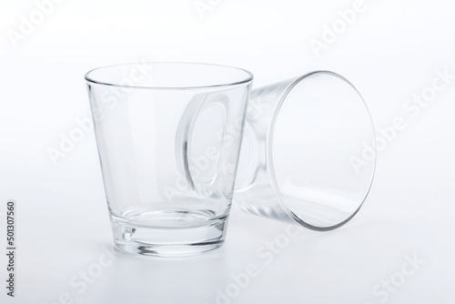 Two classic shape empty glasses on a white surface
