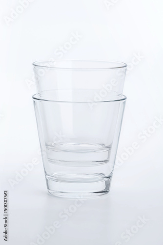 Two classic shape empty glasses on a white surface