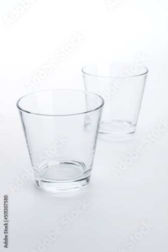 Two classic shape empty glasses on a white surface