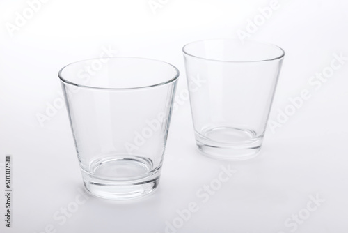 Two classic shape empty glasses on a white surface