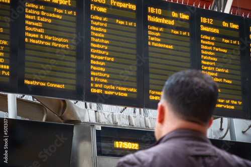 Back view of an unidentified passenger checking train timetable