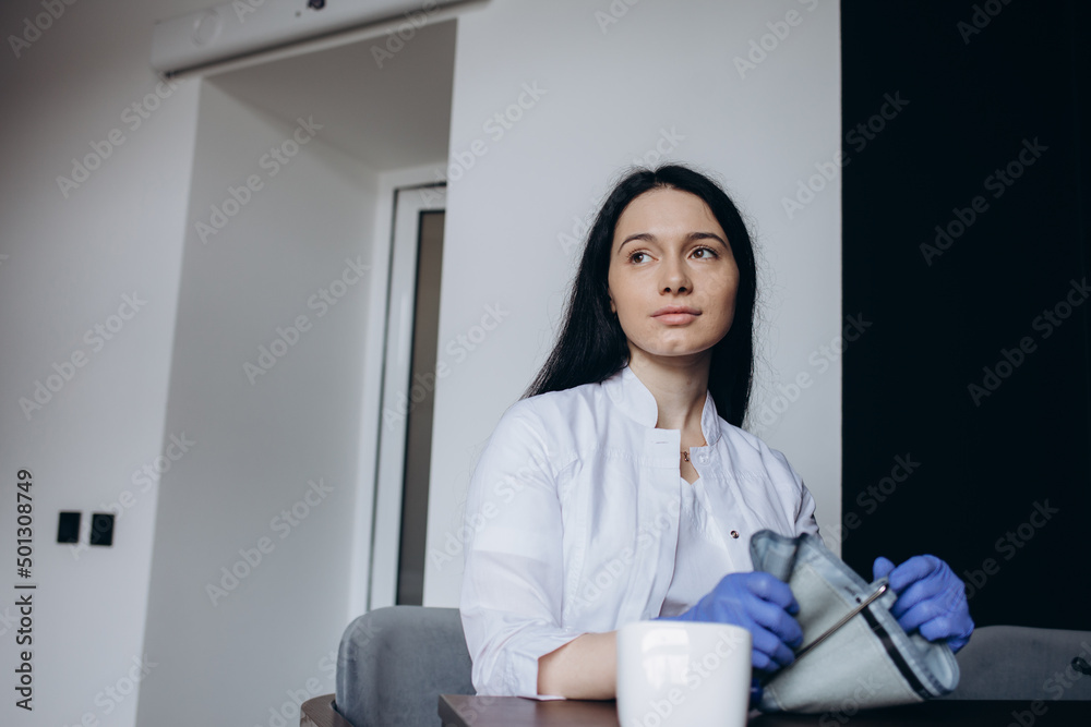 Adult woman having blood pressure test during visit at female doctor's office Adult woman having blood pressure test during visit at female doctor's office