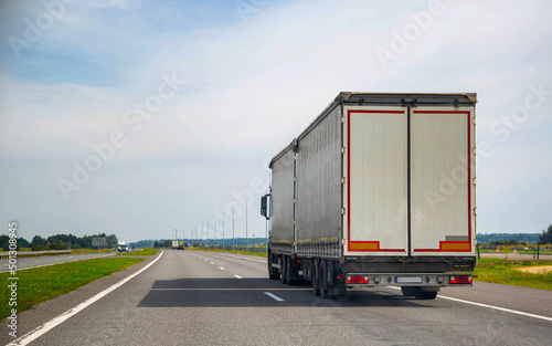A European road train is traveling with a semitrailer on the motorway. Concept of useful volume in road trains and cargo capacity. Copy space for text, sanctions