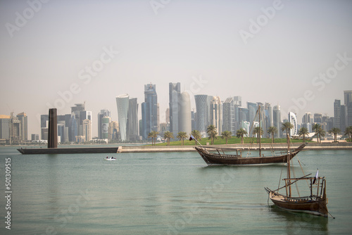 Doha,Qatar- April 24,2022 :  Traditional dhow boats with the futuristic skyline of Doha in the background.