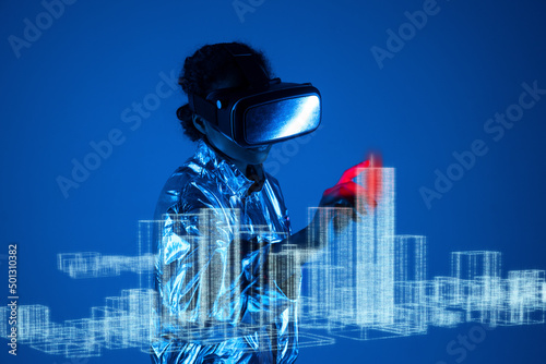 Woman wearing virtual reality simulator touching graph on screen against blue background