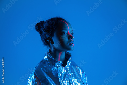Laser light falling on woman's face against blue background photo