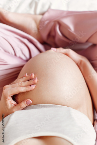 Pregnant woman holding her hands on her belly