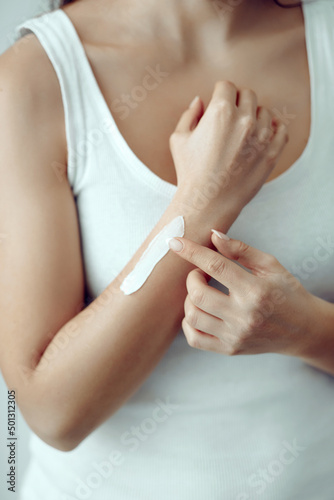 Woman hands applying moisturizing cream to her skin. Soft skin, skincare concept. Hand skin care.