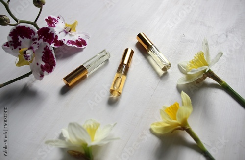 perfume bottles with orchid, daffodil flower aroma on a white background